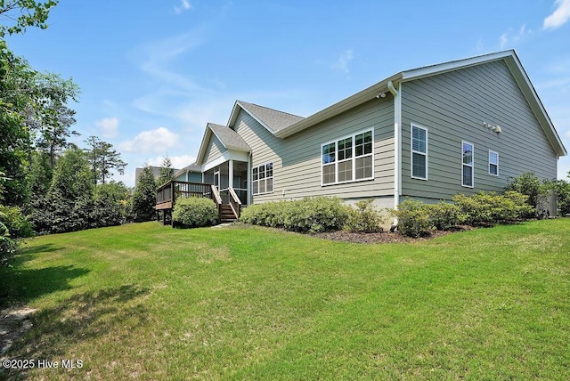 view of side of property featuring a deck and a yard