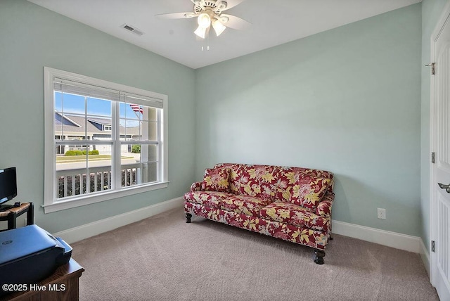 sitting room featuring carpet, a ceiling fan, and baseboards