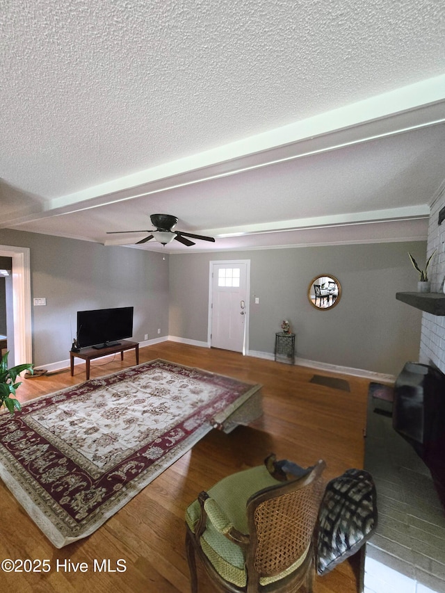 1120 Princeton Kenly Rd, Kenly, NC 27542 - living area with wood finished floors, a ceiling fan, a textured ceiling, and baseboards
