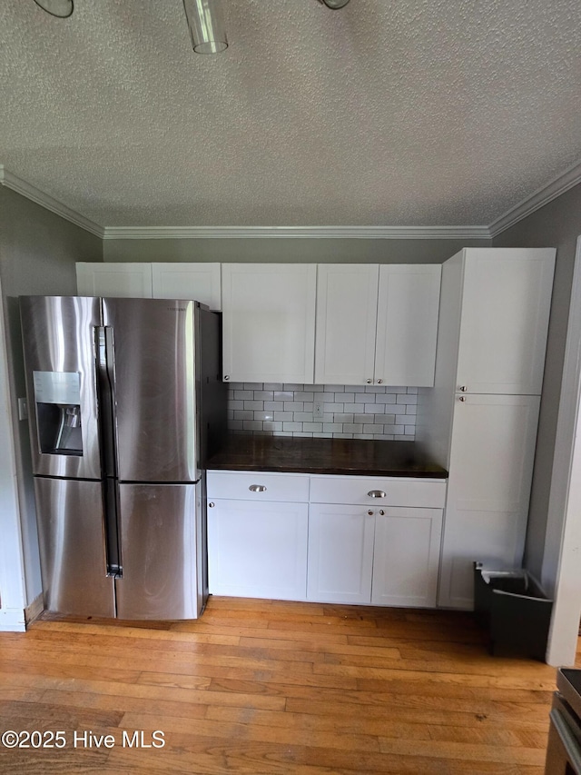 1120 Princeton Kenly Rd, Kenly, NC 27542 - kitchen with stainless steel fridge, crown molding, dark countertops, a textured ceiling, and white cabinets