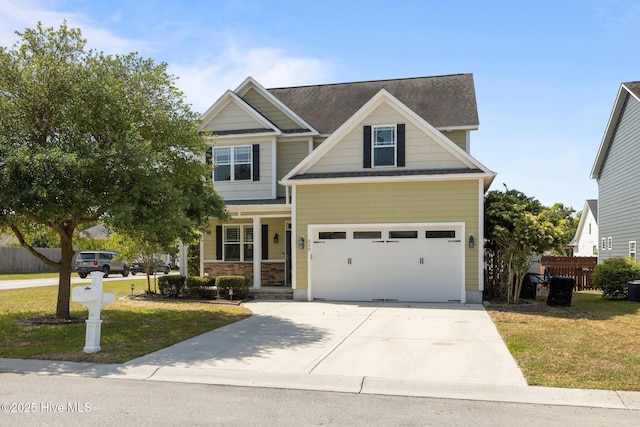 craftsman inspired home with fence, a garage, a front lawn, and driveway