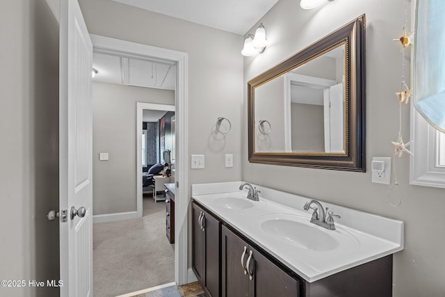 full bathroom featuring double vanity, baseboards, and a sink