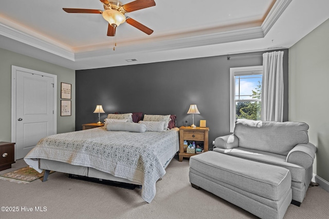 bedroom featuring light colored carpet, visible vents, crown molding, ceiling fan, and a tray ceiling