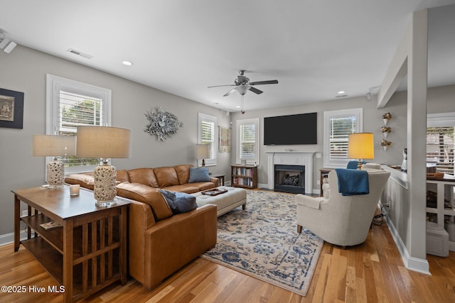 living room with a ceiling fan, a fireplace with flush hearth, visible vents, light wood-style floors, and recessed lighting