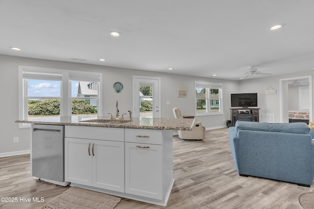 kitchen featuring a sink, dishwasher, ceiling fan, a center island with sink, and open floor plan