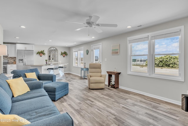 living area featuring light wood-type flooring, baseboards, recessed lighting, and ceiling fan