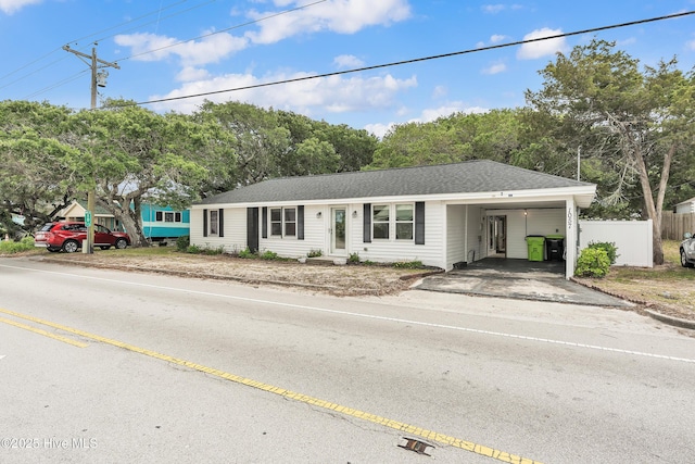 single story home with asphalt driveway, fence, and an attached carport