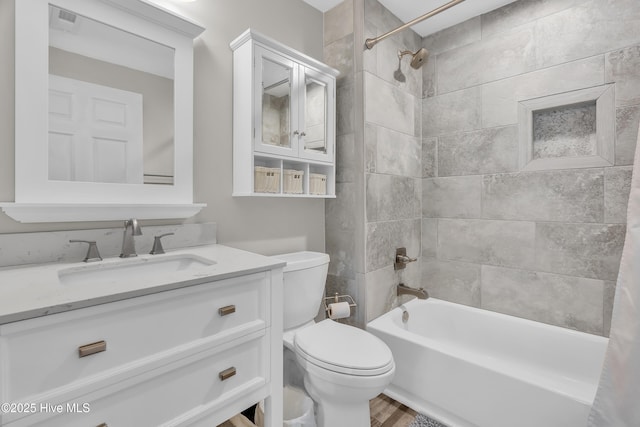 bathroom featuring toilet, vanity, shower / bathtub combination, and wood finished floors