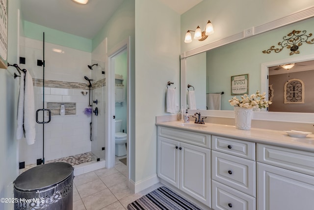 bathroom featuring tile patterned floors, vanity, toilet, and a stall shower