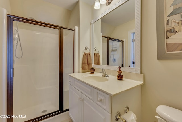 bathroom featuring a stall shower, vanity, and toilet