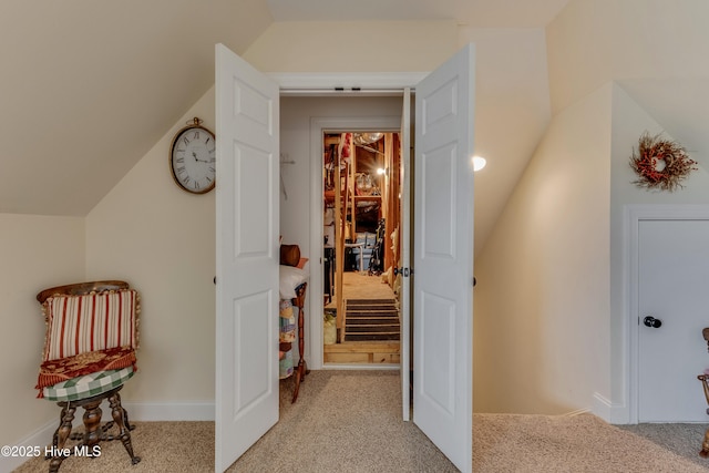 corridor featuring light colored carpet and vaulted ceiling