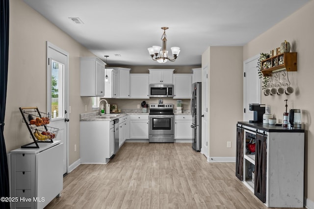 kitchen with a notable chandelier, light wood-type flooring, visible vents, baseboards, and appliances with stainless steel finishes