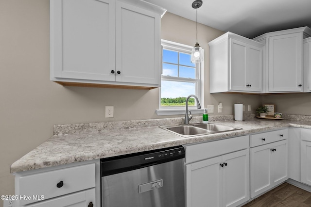 kitchen with light countertops, white cabinets, a sink, and dishwasher