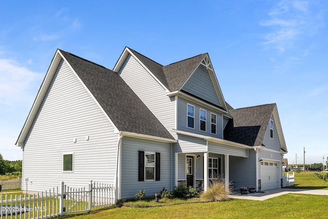 view of side of property with fence, a porch, roof with shingles, a yard, and driveway