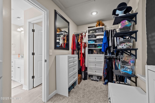 walk in closet with light colored carpet and visible vents