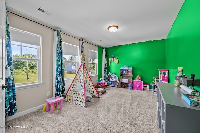 rec room with carpet, visible vents, and baseboards