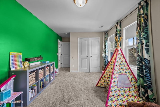 recreation room featuring baseboards and carpet