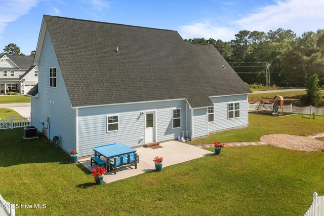 rear view of house featuring a yard, fence, a patio area, central AC unit, and roof with shingles