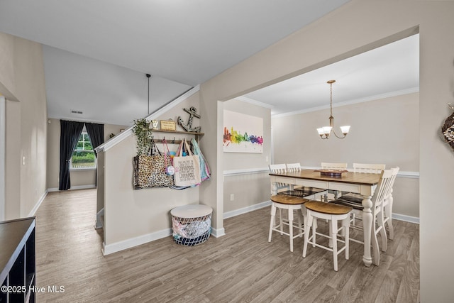 dining room with baseboards, ornamental molding, an inviting chandelier, wood finished floors, and stairway