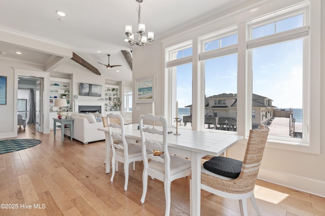 26 Seagull St Unit B, Wrightsville Beach, NC 28480 - dining area featuring ceiling fan, a fireplace, a chandelier, baseboards, and ornamental molding