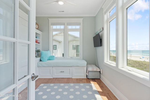 26 Seagull St Unit B, Wrightsville Beach, NC 28480 - bedroom featuring multiple windows, ornamental molding, light wood finished floors, and a ceiling fan