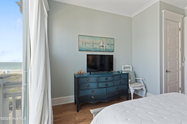 26 Seagull St Unit B, Wrightsville Beach, NC 28480 - bedroom with crown molding, multiple windows, baseboards, wood finished floors, and a water view