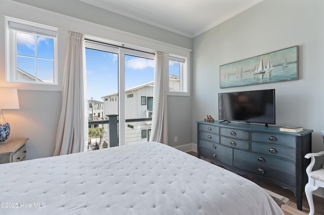 26 Seagull St Unit B, Wrightsville Beach, NC 28480 - bedroom with access to exterior, ornamental molding, wood finished floors, and baseboards