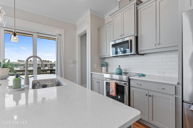 26 Seagull St Unit B, Wrightsville Beach, NC 28480 - kitchen featuring stainless steel appliances, gray cabinets, a sink, crown molding, and backsplash