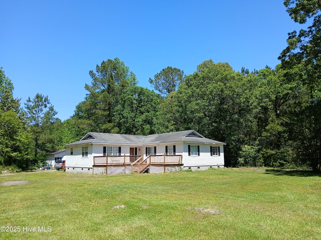 view of front of house featuring crawl space, a wooden deck, a wooded view, and a front yard