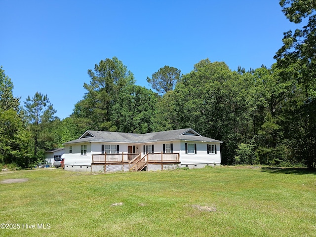 view of front of house featuring crawl space, a wooden deck, a wooded view, and a front yard