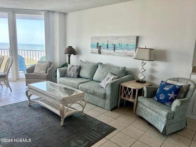 living room featuring light tile patterned floors, a textured ceiling, and a water view