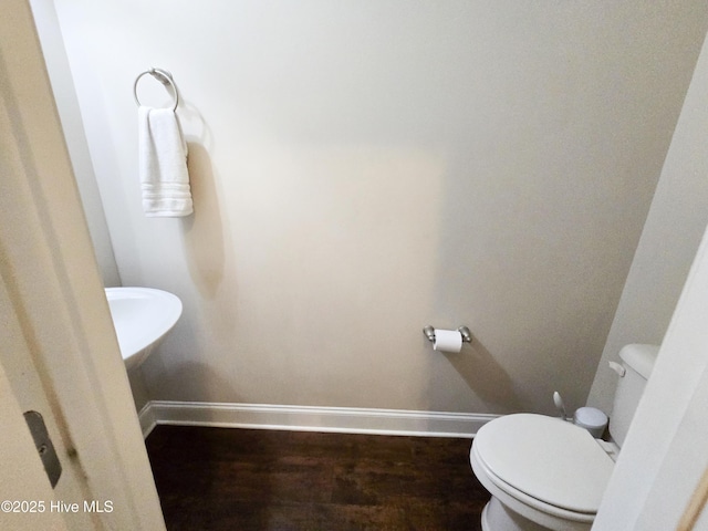 bathroom featuring toilet, baseboards, and wood finished floors