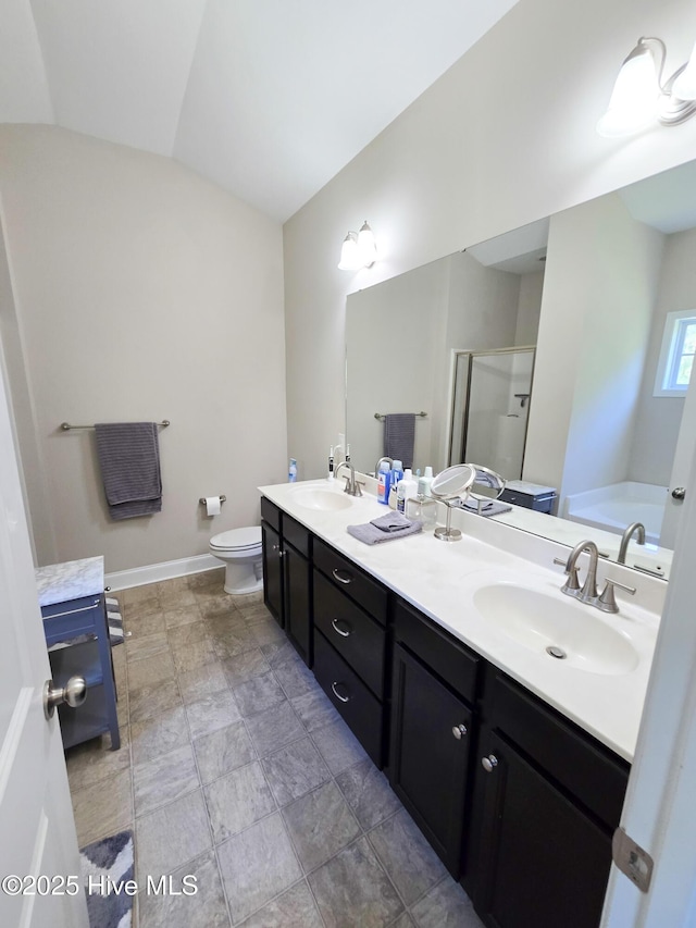 bathroom with a sink, toilet, a shower stall, double vanity, and a bath