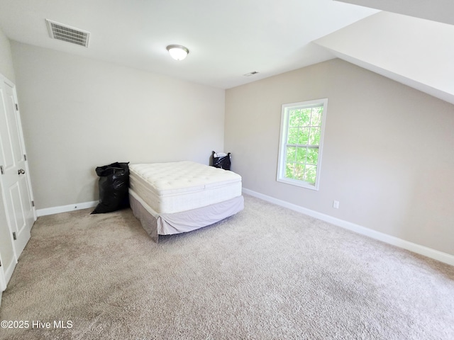 bedroom with vaulted ceiling, carpet flooring, baseboards, and visible vents
