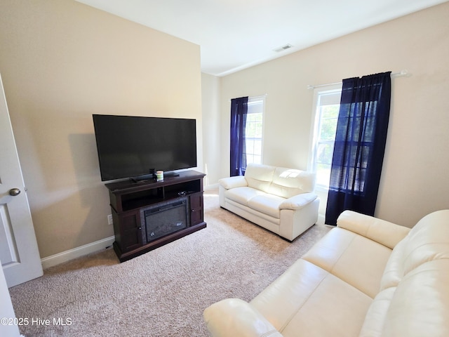 living area featuring visible vents, baseboards, and carpet floors