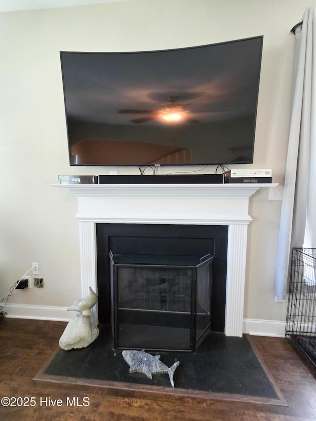 details with baseboards, a fireplace with flush hearth, and wood finished floors