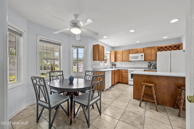 kitchen with white appliances, light countertops, a sink, light tile patterned floors, and recessed lighting