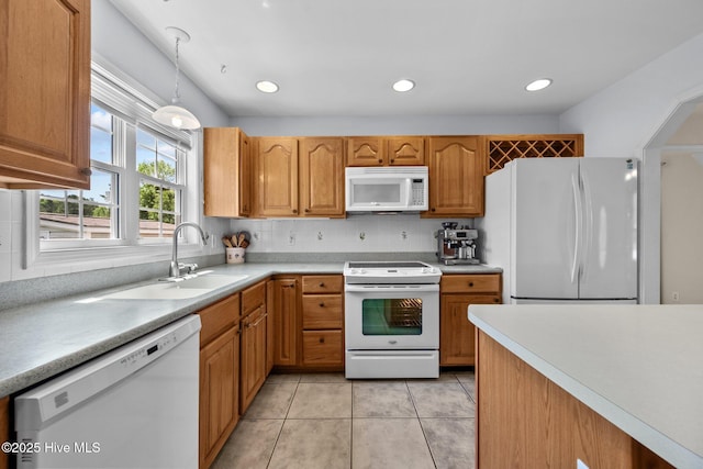 kitchen featuring white appliances, a sink, decorative light fixtures, light countertops, and light tile patterned floors