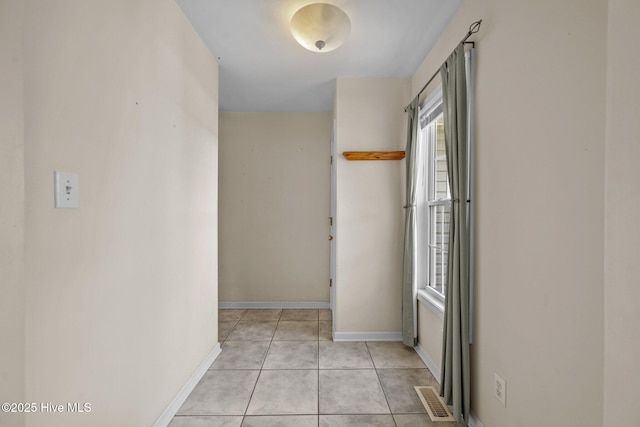 hallway featuring light tile patterned floors and baseboards