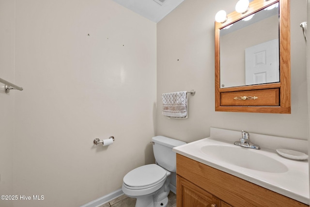 bathroom featuring toilet, vanity, and tile patterned flooring