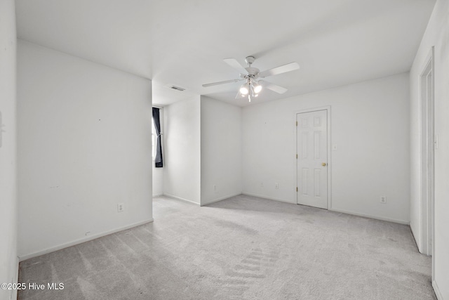 carpeted empty room featuring a ceiling fan and baseboards