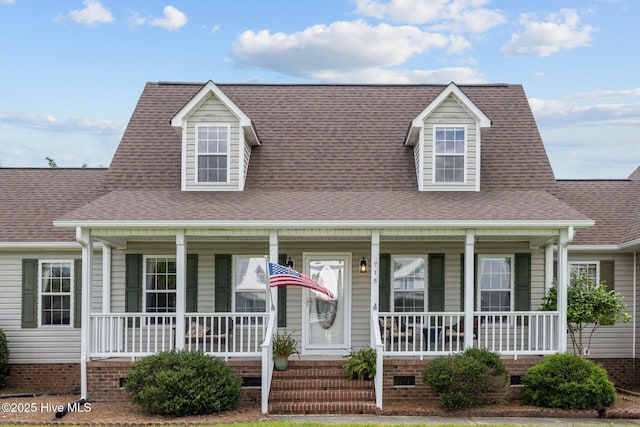cape cod-style house with covered porch, roof with shingles, and crawl space