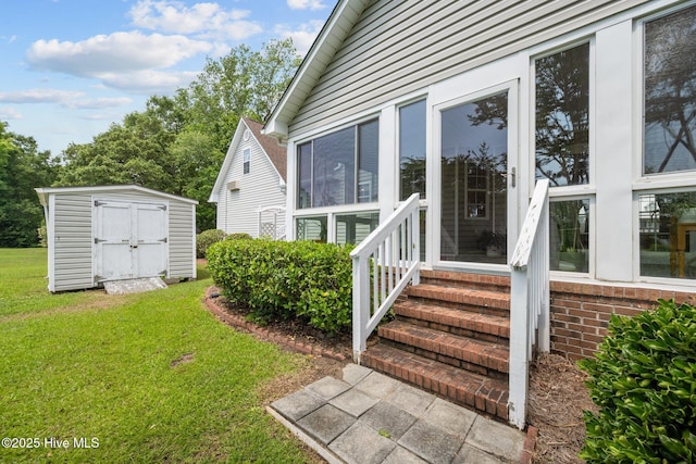 entrance to property featuring a lawn and brick siding