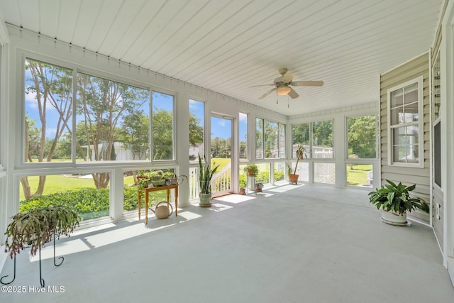 unfurnished sunroom featuring a ceiling fan