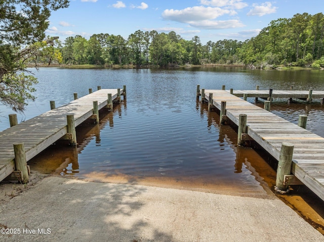 dock featuring a boat ramp, a water view, and a forest view