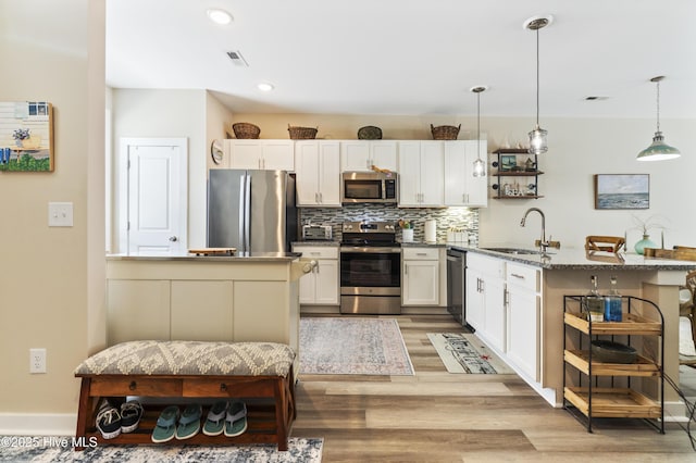 326 Starfish Ln, Sneads Ferry, NC 28460 - kitchen featuring a peninsula, light wood finished floors, a sink, stainless steel appliances, and white cabinets