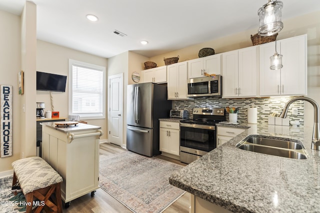 326 Starfish Ln, Sneads Ferry, NC 28460 - kitchen with a sink, stainless steel appliances, light stone countertops, light wood-style floors, and tasteful backsplash