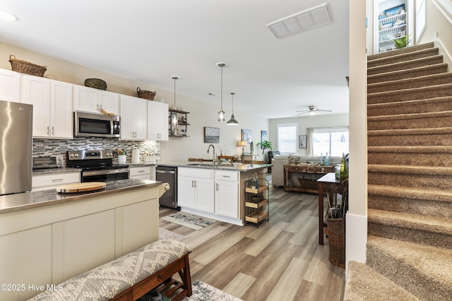 326 Starfish Ln, Sneads Ferry, NC 28460 - kitchen featuring a sink, a peninsula, stainless steel appliances, visible vents, and light wood-style flooring