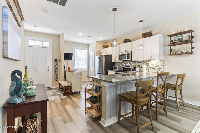 326 Starfish Ln, Sneads Ferry, NC 28460 - kitchen with a peninsula, light wood-type flooring, stainless steel appliances, and a breakfast bar