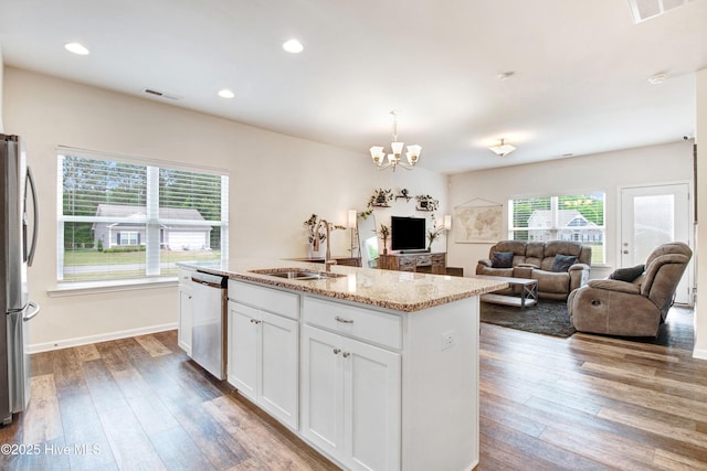 kitchen featuring hardwood / wood-style flooring, stainless steel appliances, visible vents, white cabinetry, and a notable chandelier